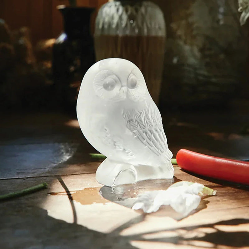White glass owl figurine with detailed feathers and round body on a small base