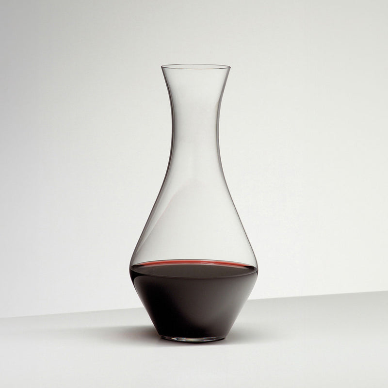 Glass decanter with clear neck and dark red wine base, tall slender bottle shape
