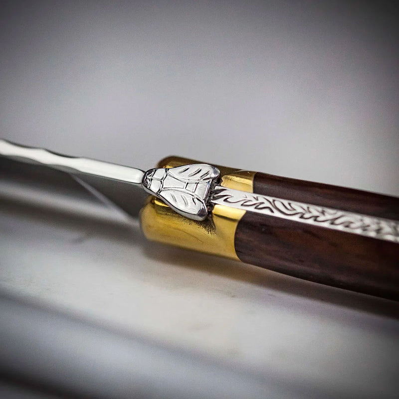 Carving knife close-up with engraved rosewood handle and polished metal bolster