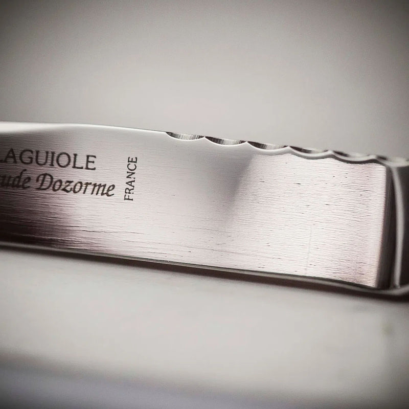 Stainless steel carving knife blade with scalloped spine and engraved maker marks