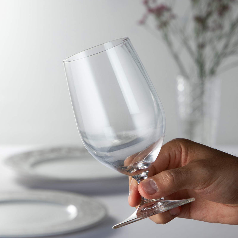 Clear stemmed beer glass held in hand, rounded bowl and short stem
