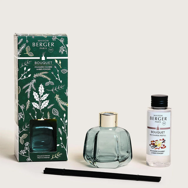Reed diffuser set with teal glass bottle, black reeds, gift box, and refill bottle