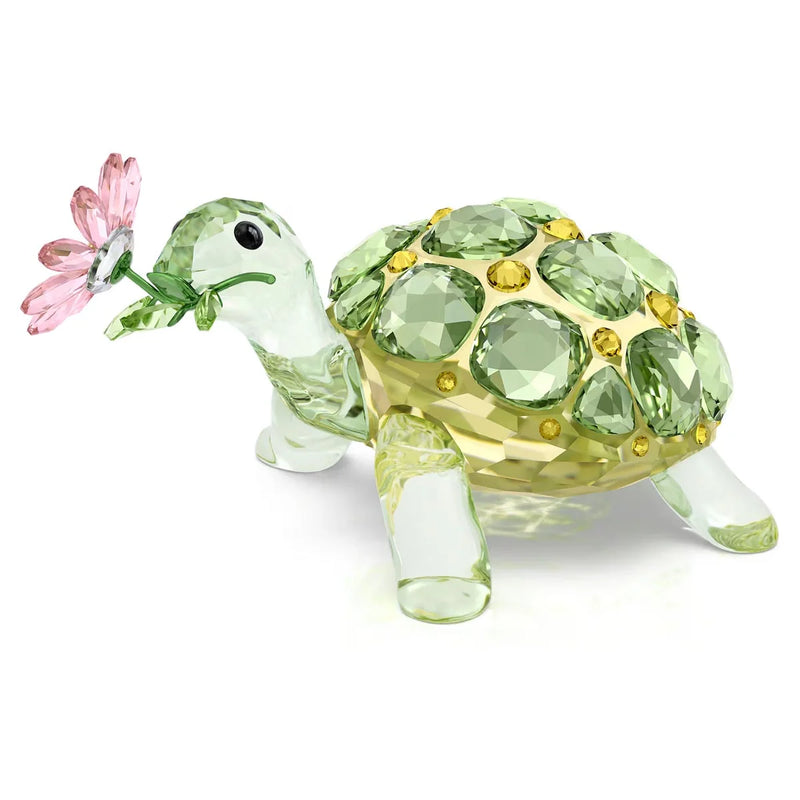 Green crystal tortoise figurine with jeweled shell, translucent legs, and a pink flower