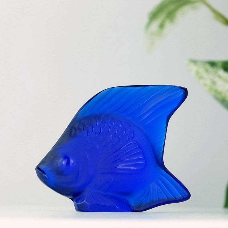 Lalique Cap Ferrat Blue Fish with a plant in the background