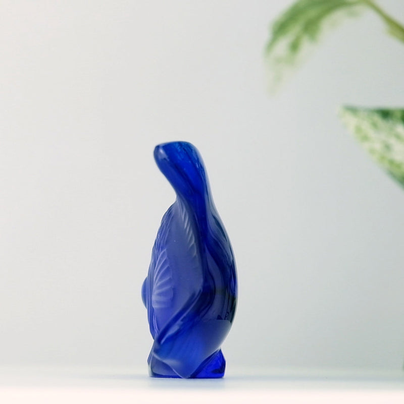 Lalique Cap Ferrat Blue Fish with a plant in the background