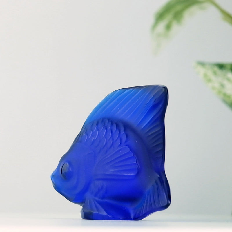 Lalique Cap Ferrat Blue Fish with a plant in the background