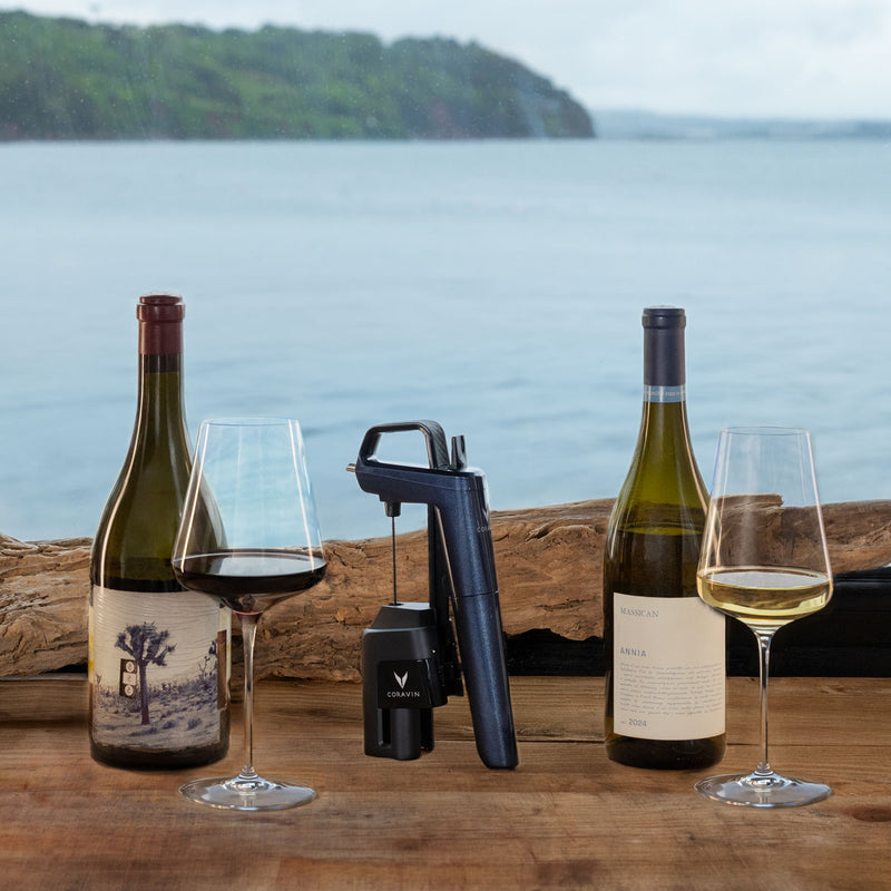 Coravin Timeless Six+ wine preservation device between bottles and glasses of wine