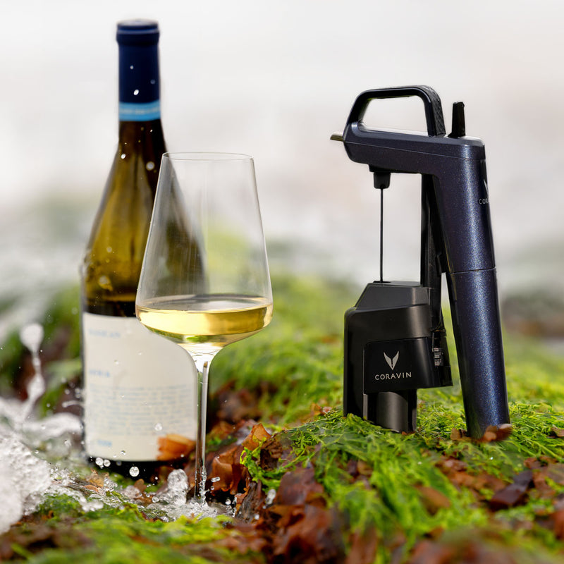 Coravin Timeless Six+ wine preservation device beside a bottle and glass of white wine