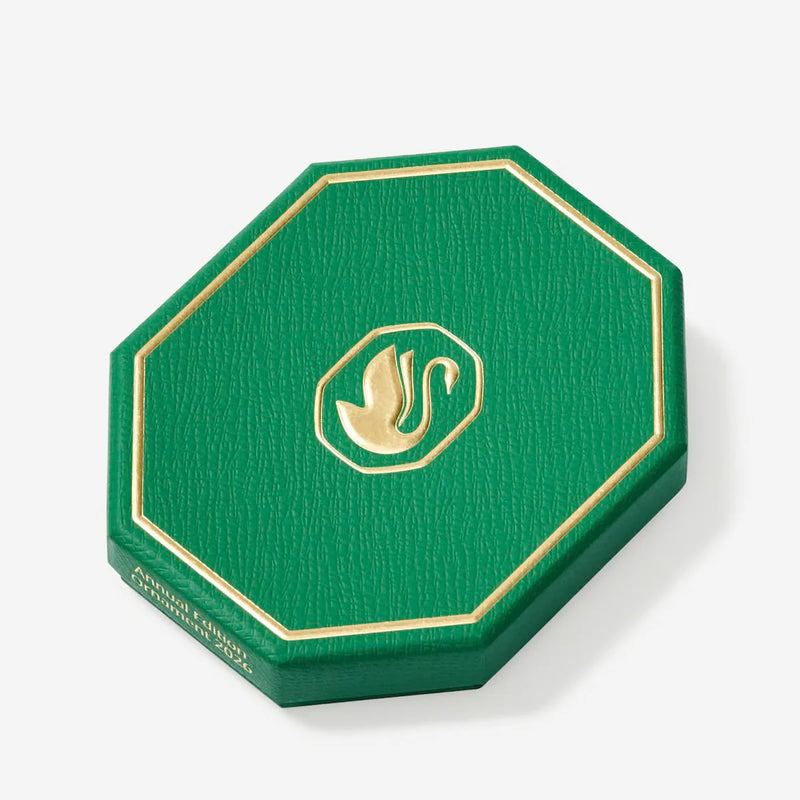Green octagonal presentation box with gold trim and emblem